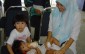 A woman and her children wait for a check-up at the FRHAM clinic in Kuala Lumpur