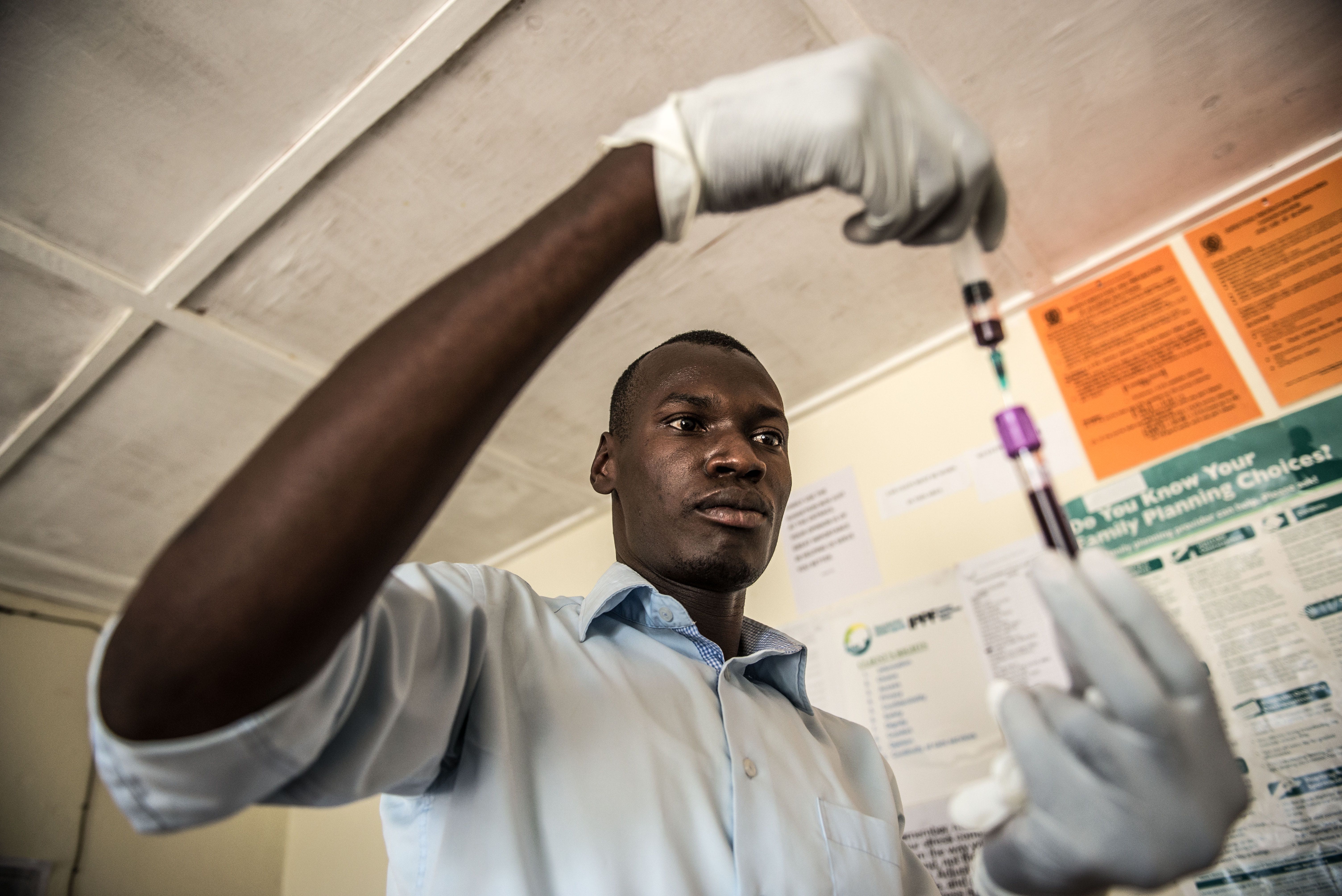 Laboratory Technician, Denis Bongoyinge, prepares a blood sample for a STI test.