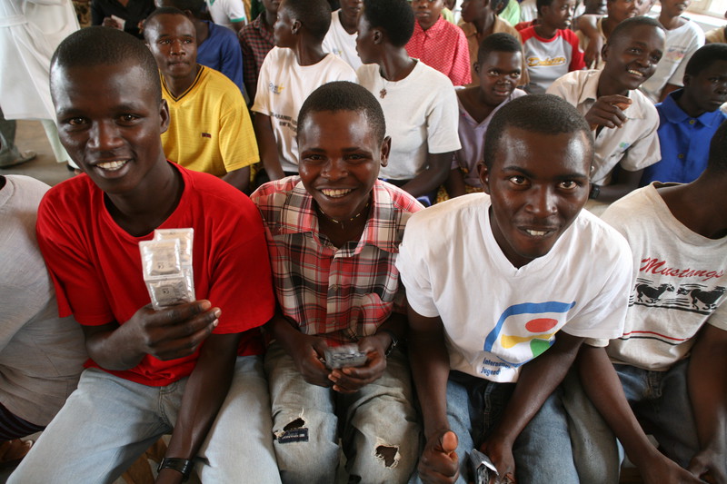 Group of young men. One holds condoms. 