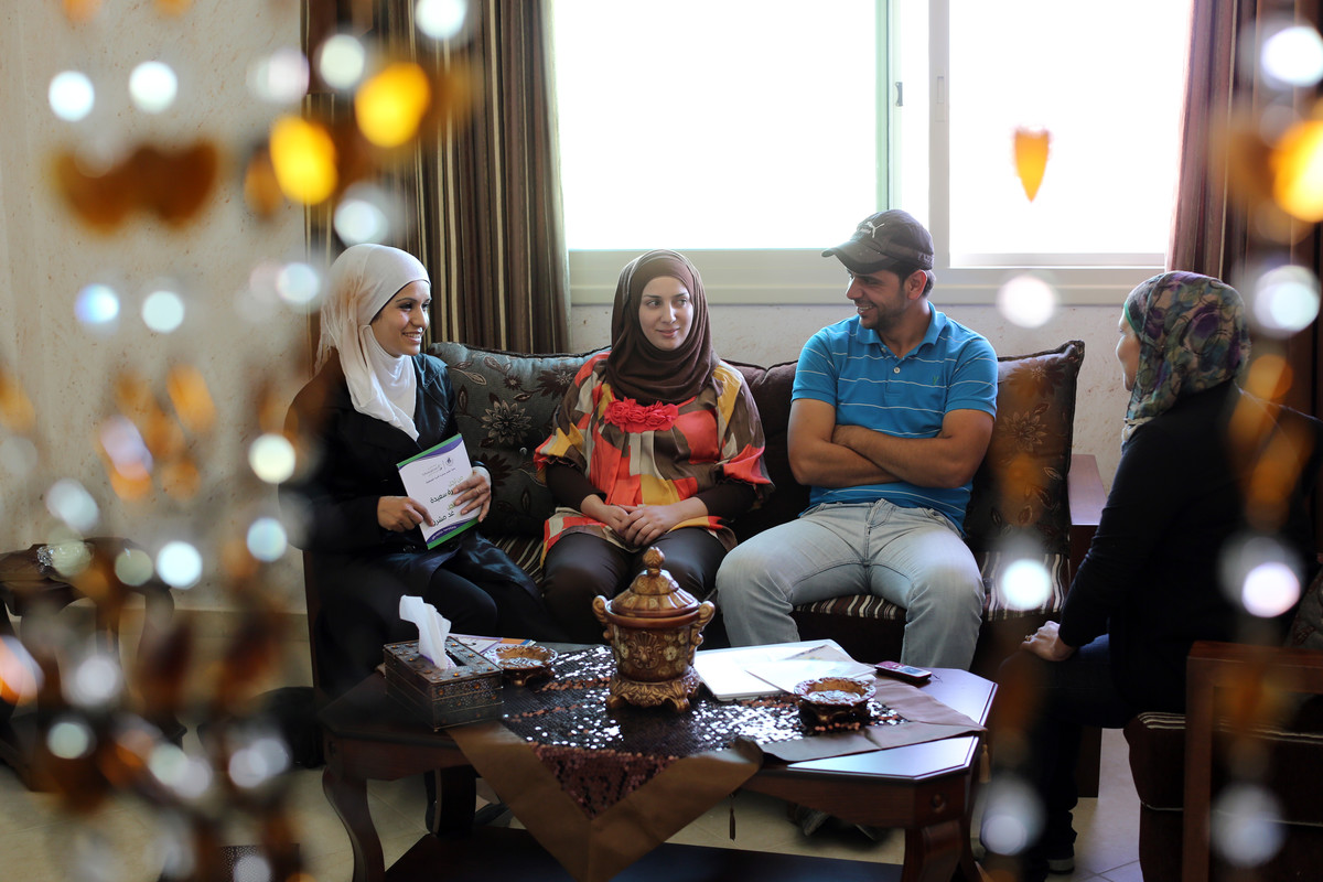 A young couple sit with a counseller