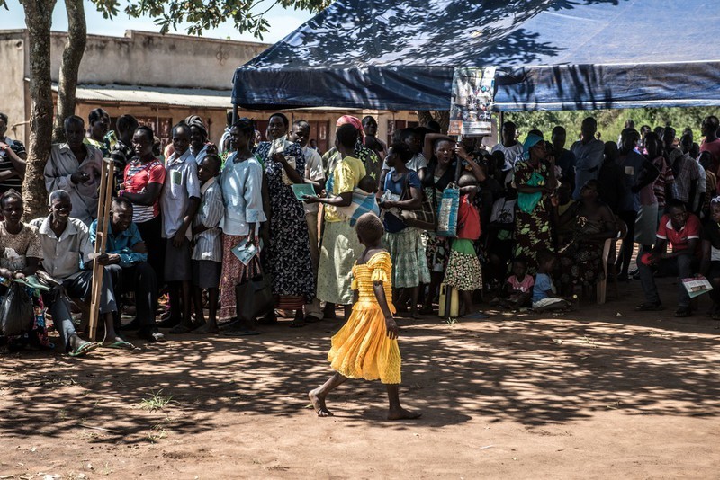 Queues of children, men and women wait in line at a clinic in Gulu, Uganda