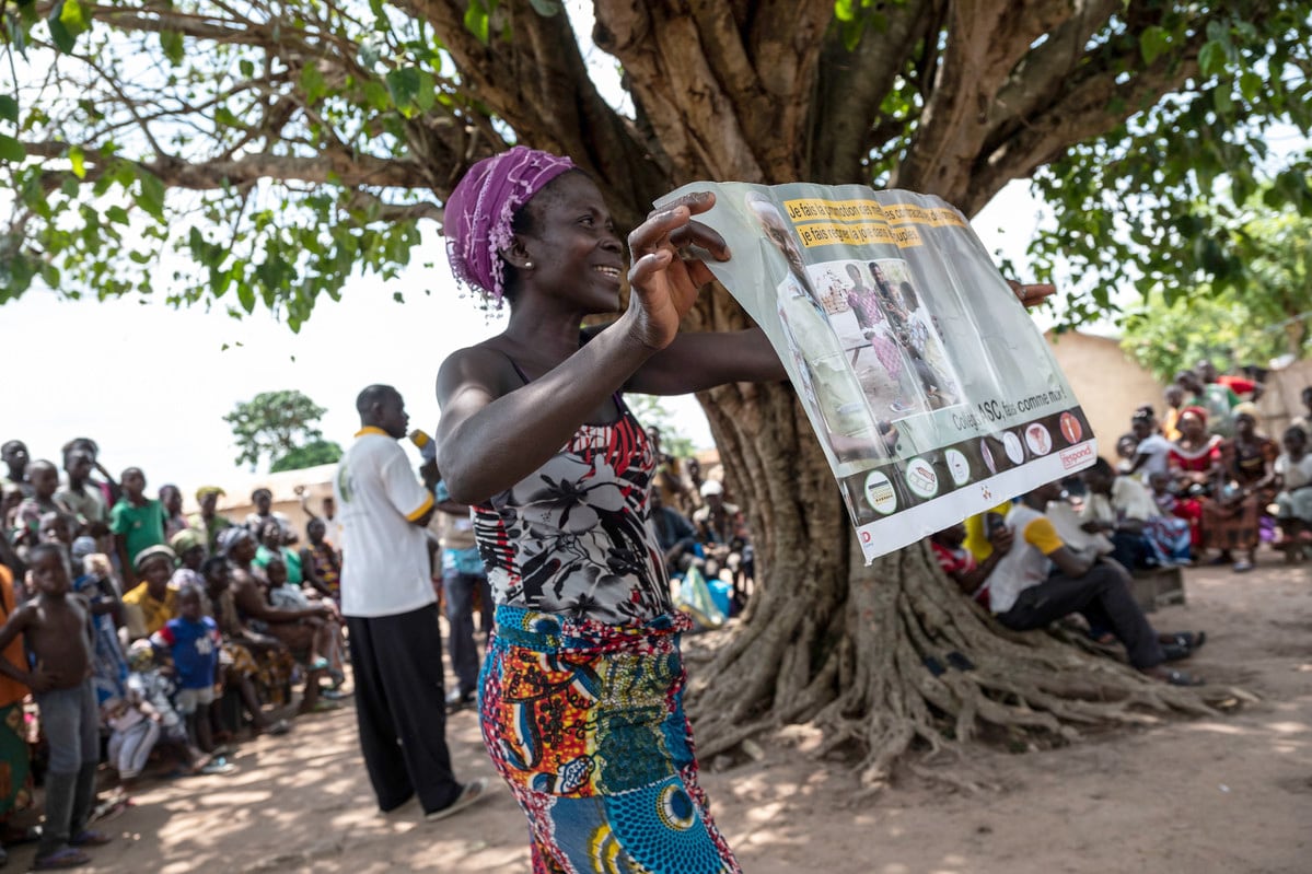 volunteer holds a family planning poster, Togo