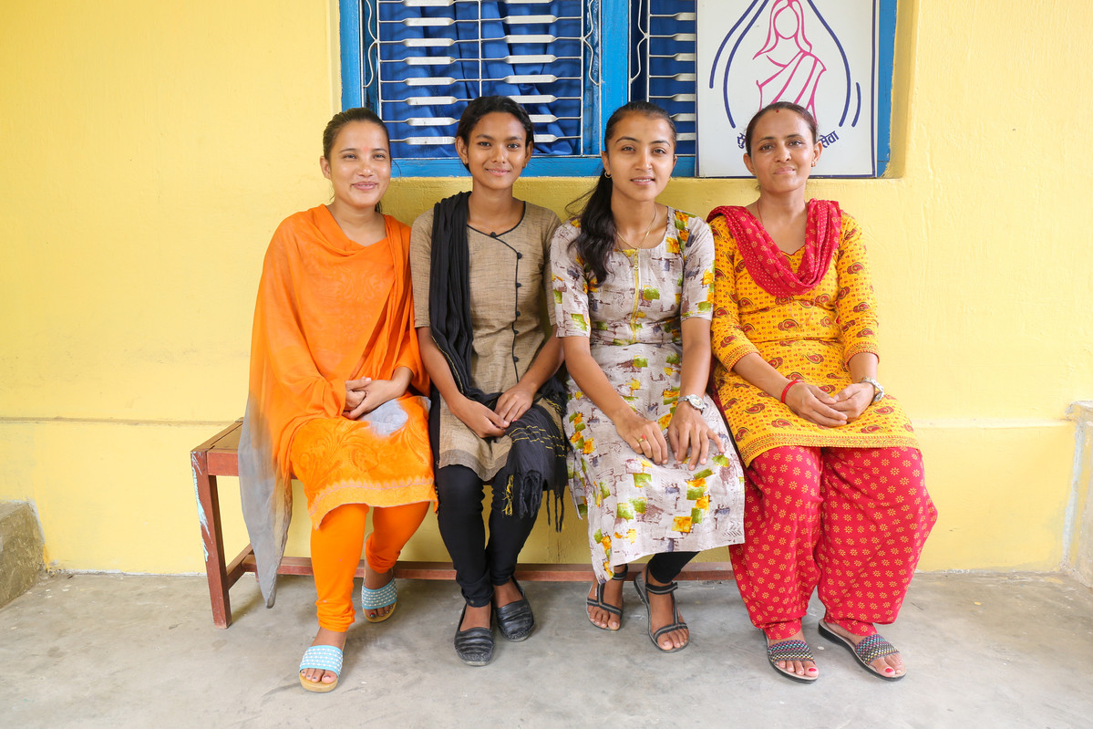 women sit outside a clinic in Nepal