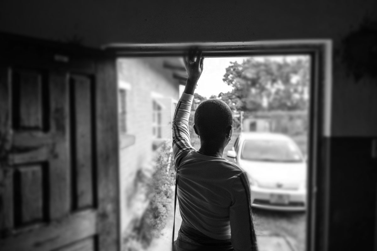 woman stand in door way - black and white