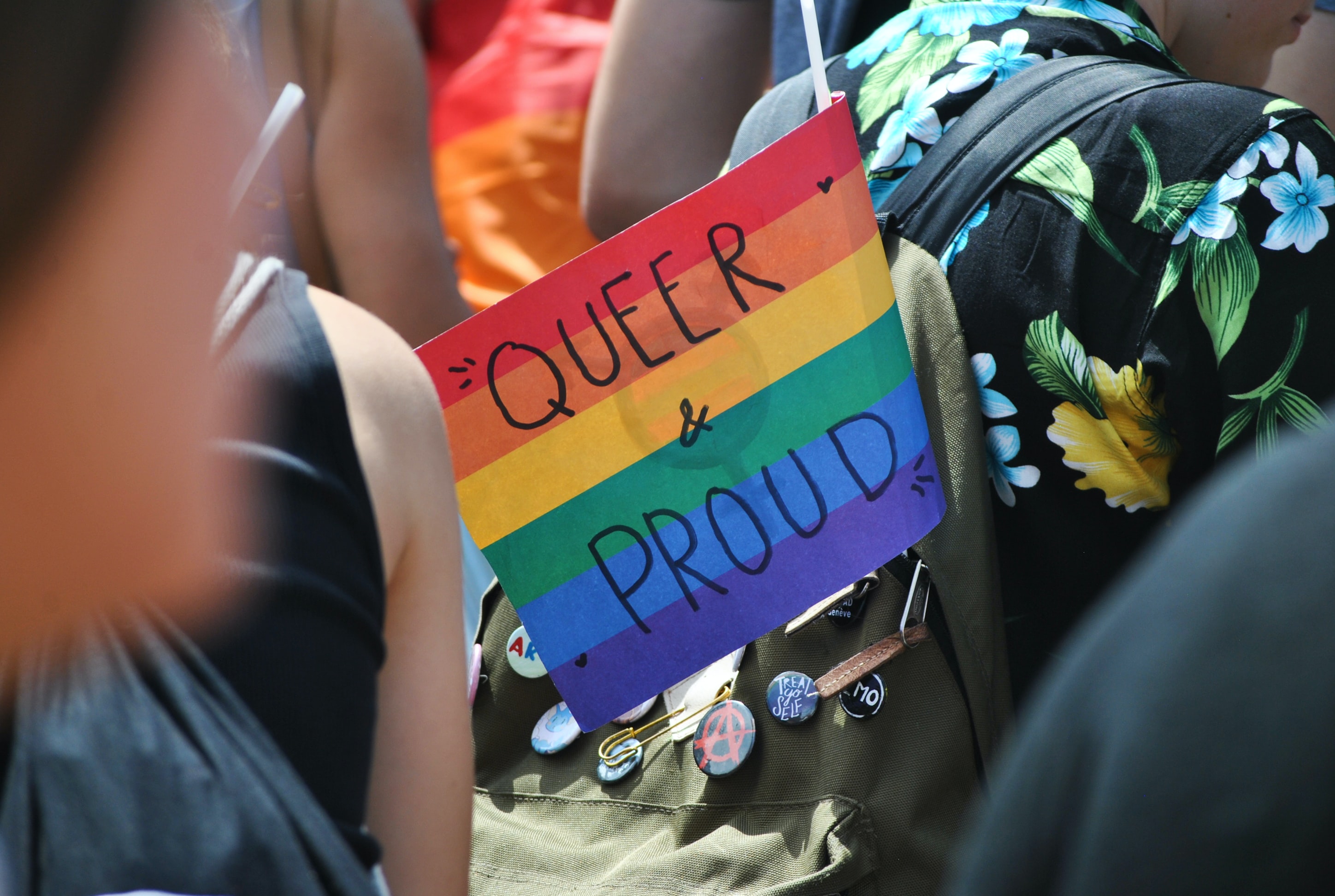 Rainbow flag which reads "queer & proud"