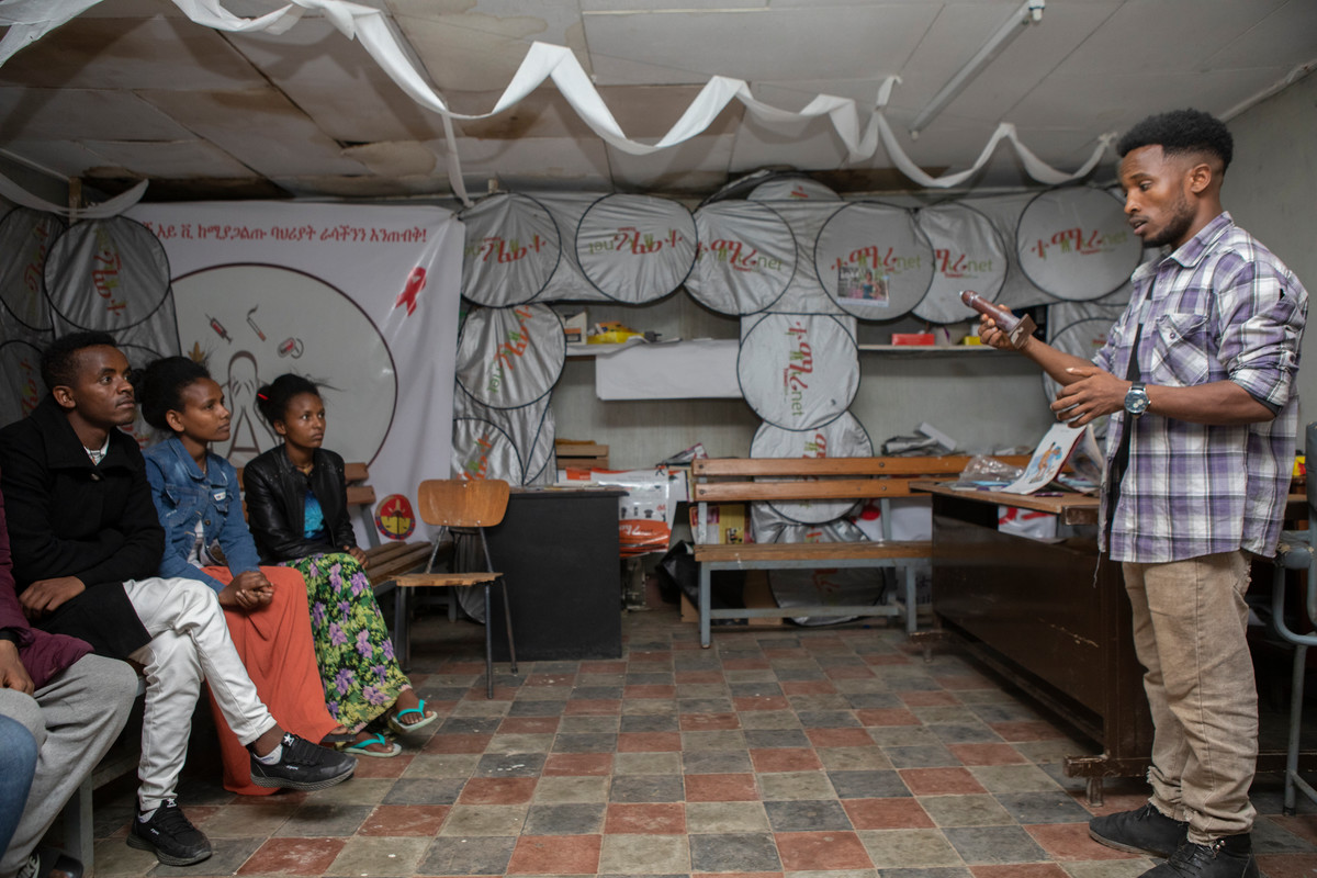 young people sit and listen to a sexual health peer educator 