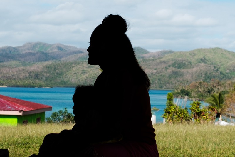 A silhouette of a woman and young child in Fiji