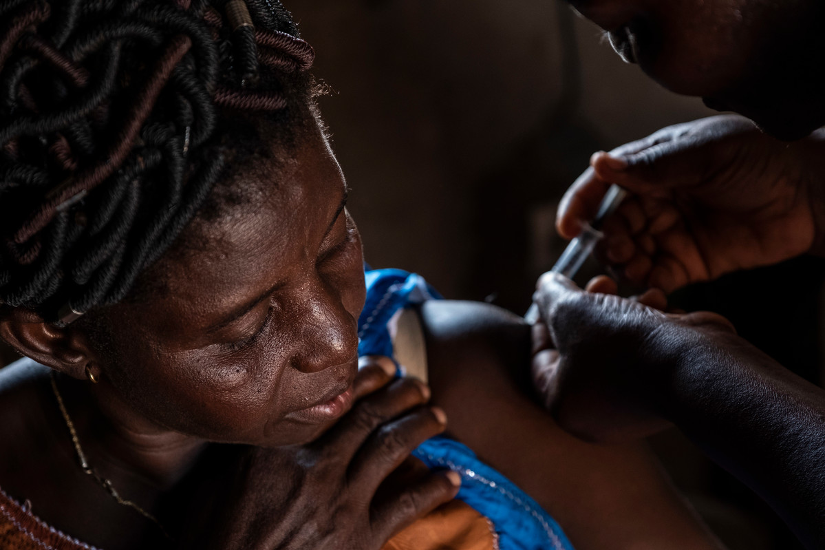 Abla Abassa, community health worker in Ilama gives Essivi Koutchona, 45, the injectable in Ilama village, Togo.