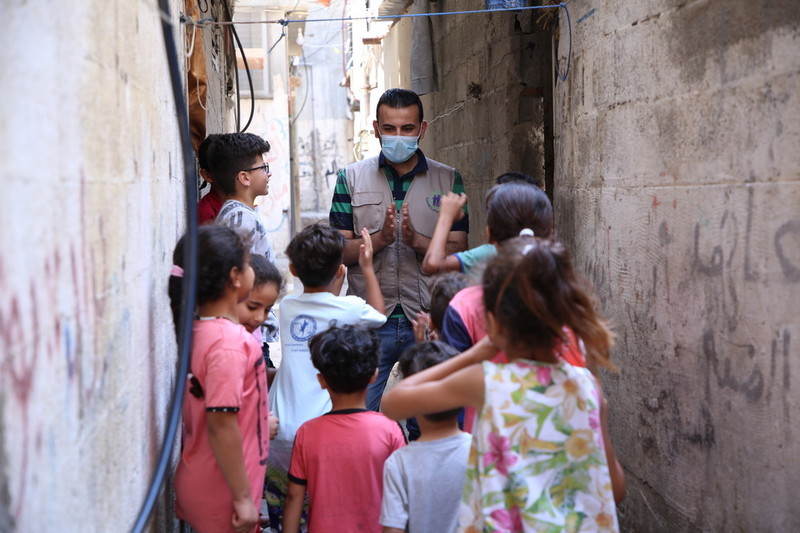 Youth volunteer entertains a group of children