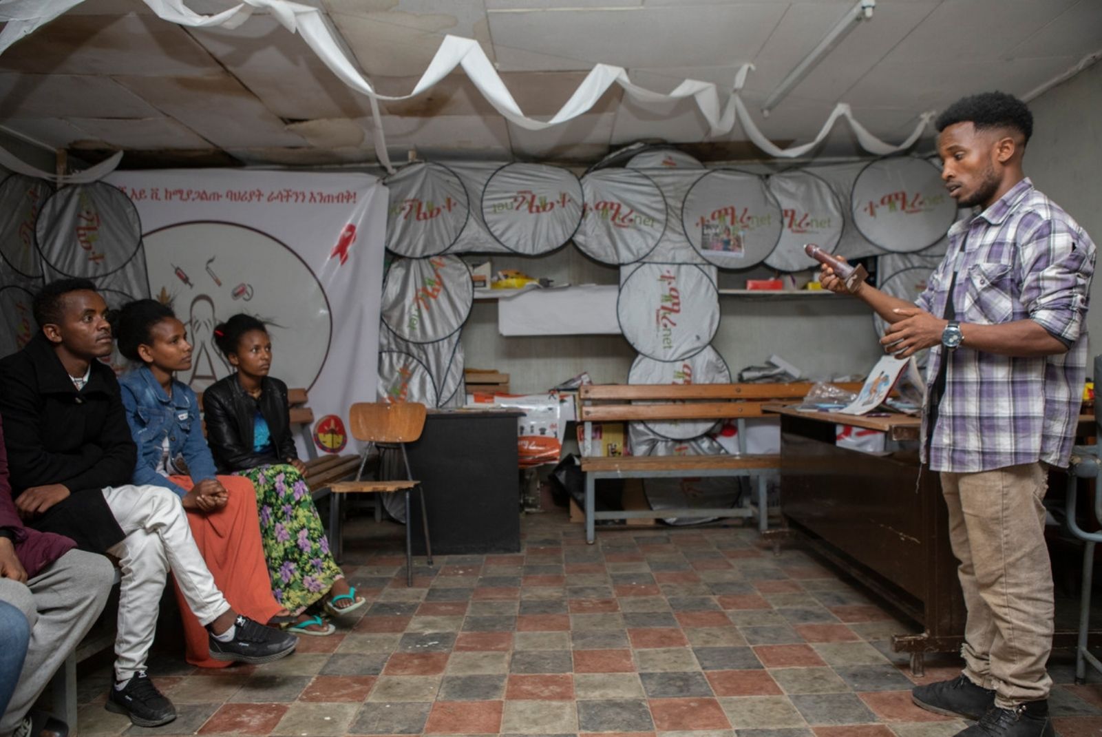 A volunteer at Makelle demonstrates to a group of young people how to put on a condom