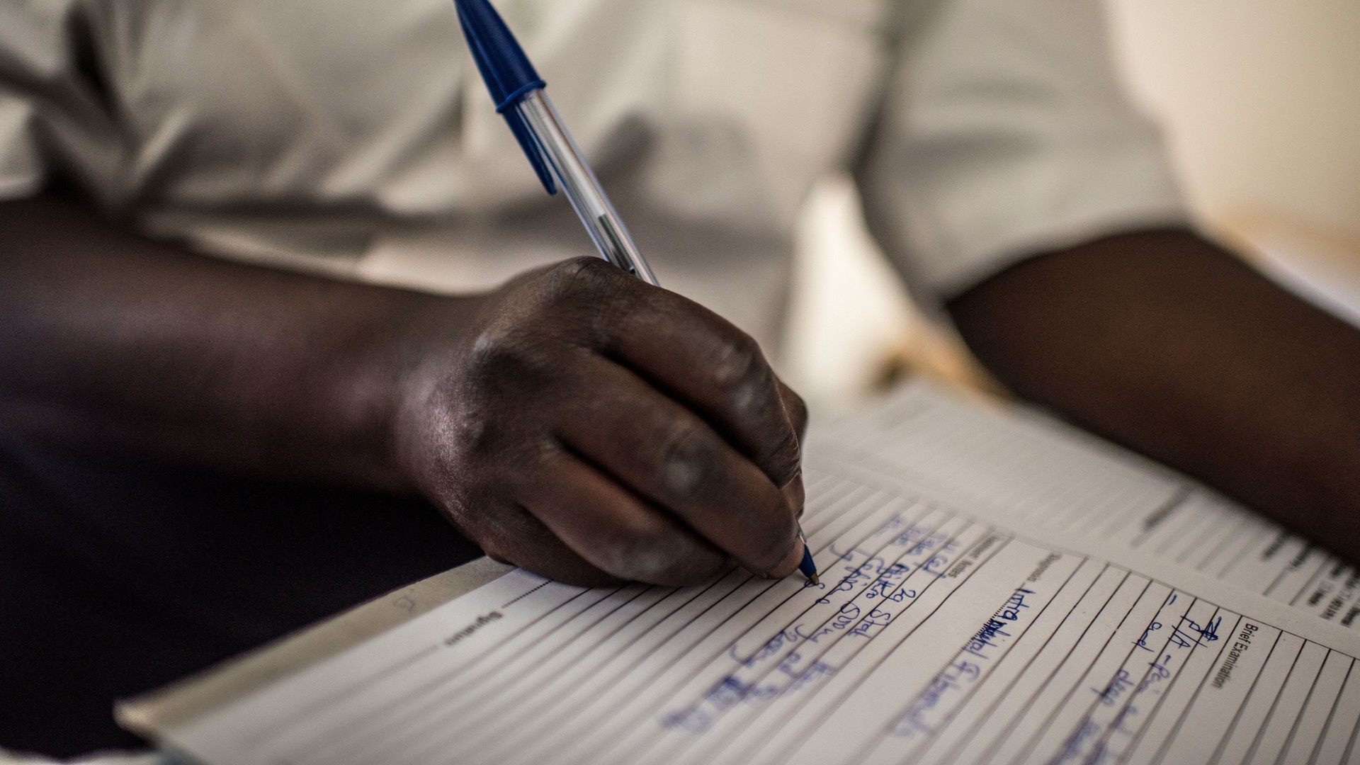 Healthcare worker writing records. 