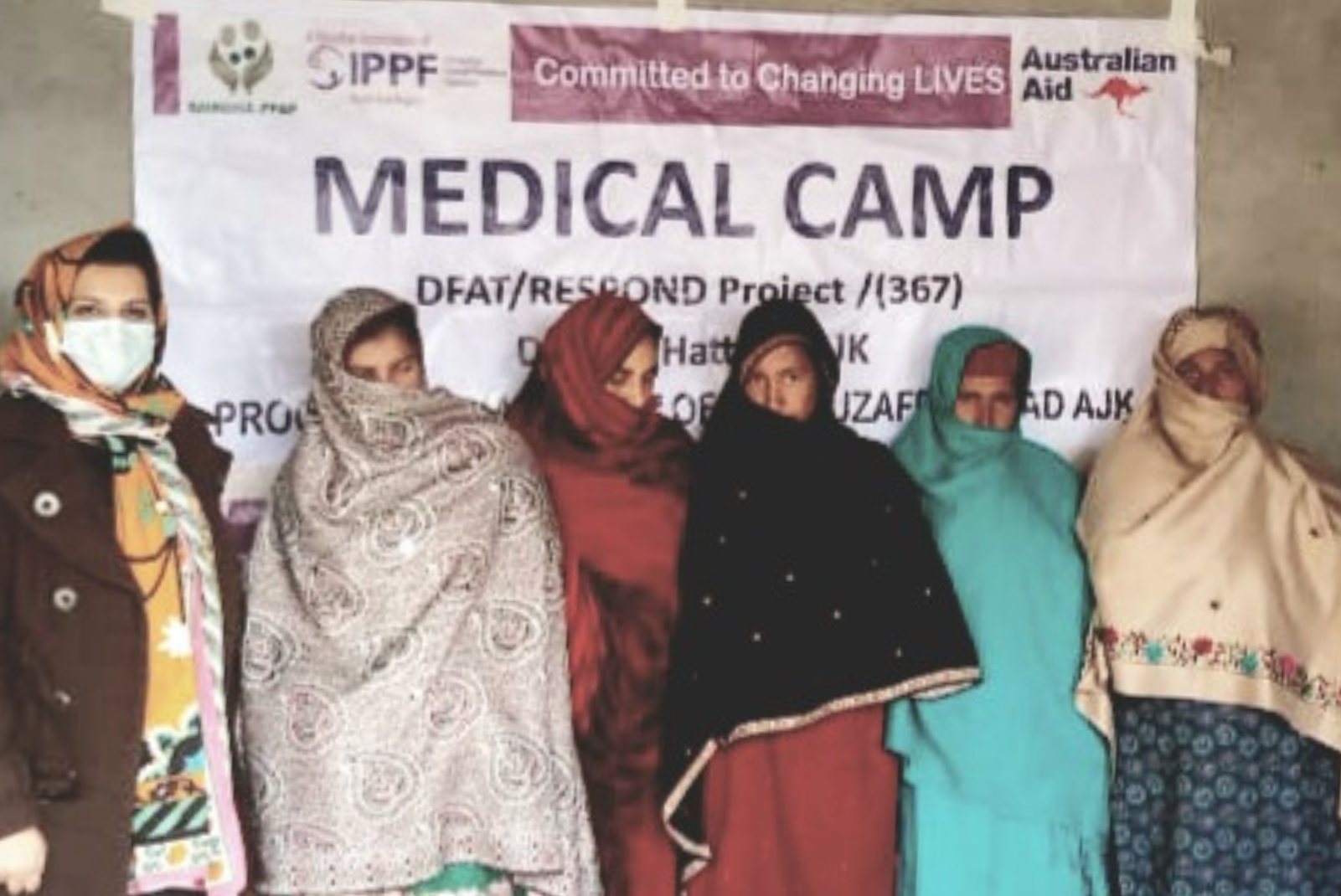 A group of women in front of a sign which says "medical camp"
