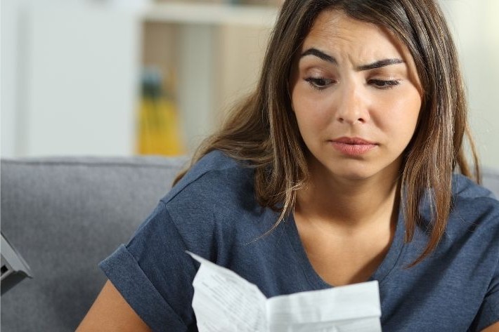 A confused-looking woman reads a leaflet