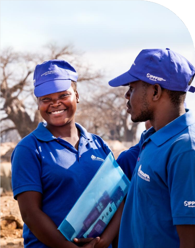Two IPPF team members in blue t-shirts and blue hats.