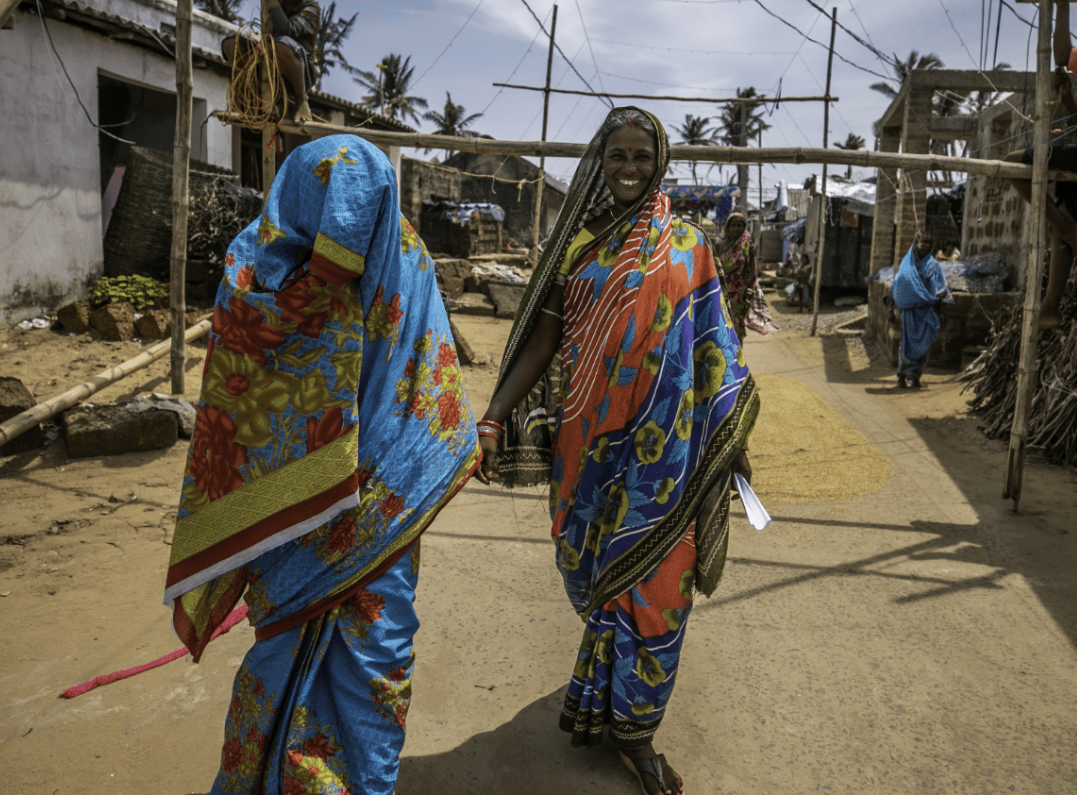 Two women walking on a road