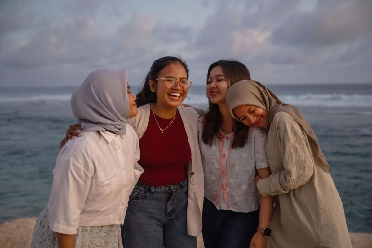 Four women in Indonesia stand together smiling. 