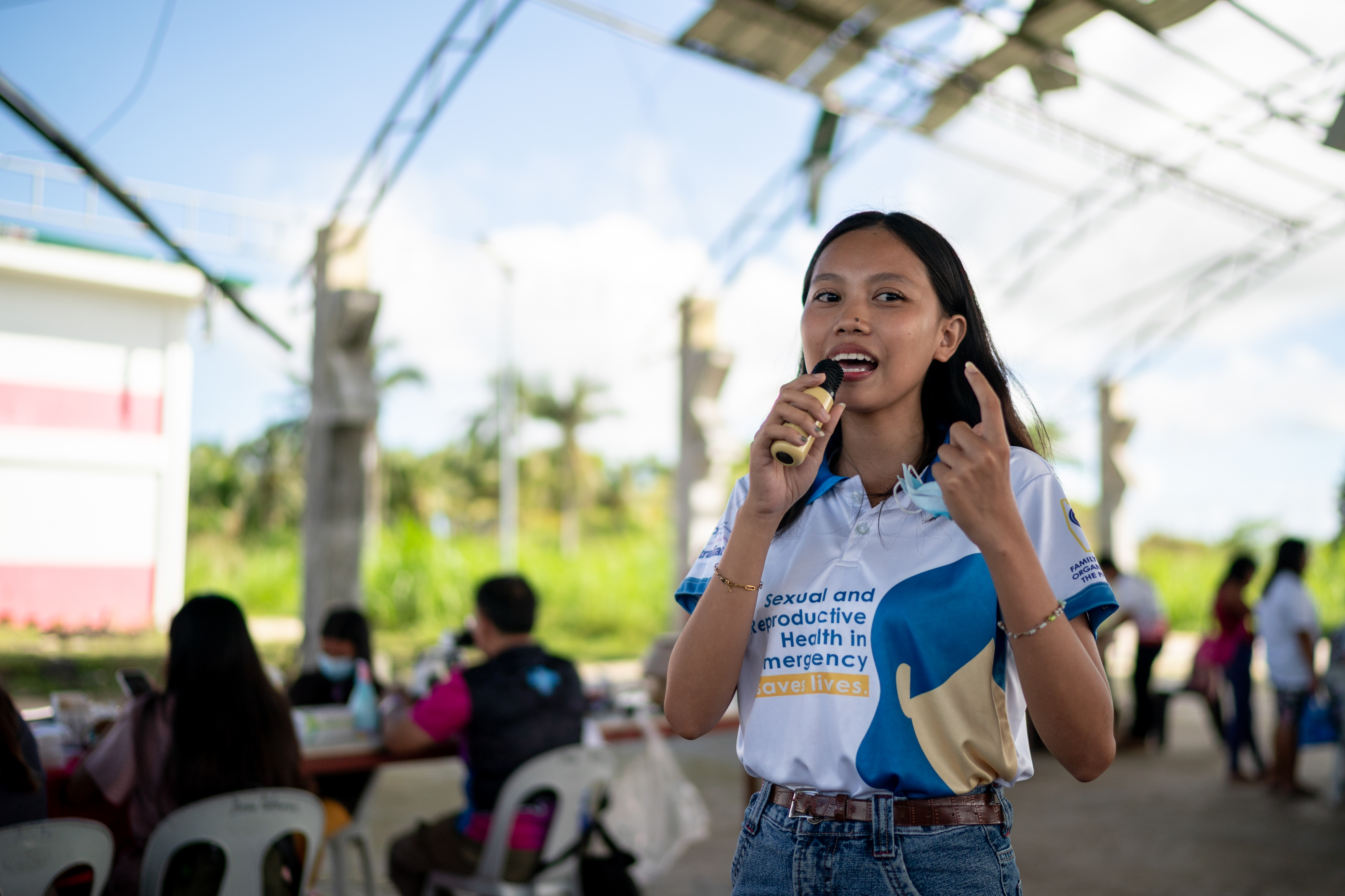 Youth Volunteer Charlaine Mae Leones speaks during a post-Typhoon Opong reproductive health medical mission at a damaged covered court in Masbate province,