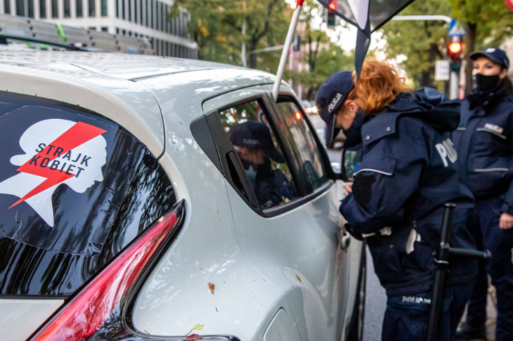 A police officer speaks with a protester in their car