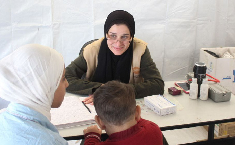 A woman and child attend a medical session.