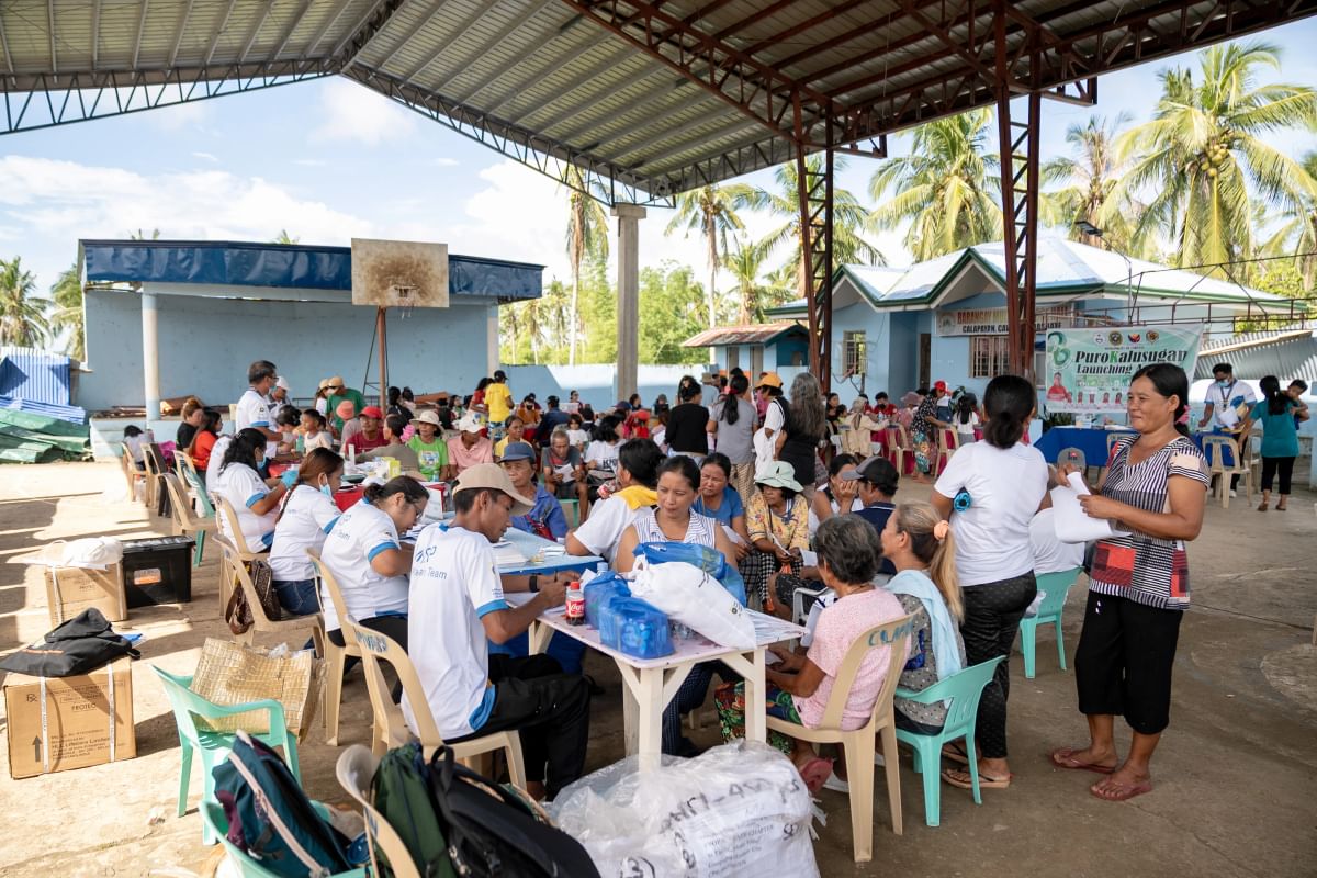 A medical outreach session takes place in a covered sports court that was damaged in the Typhoon