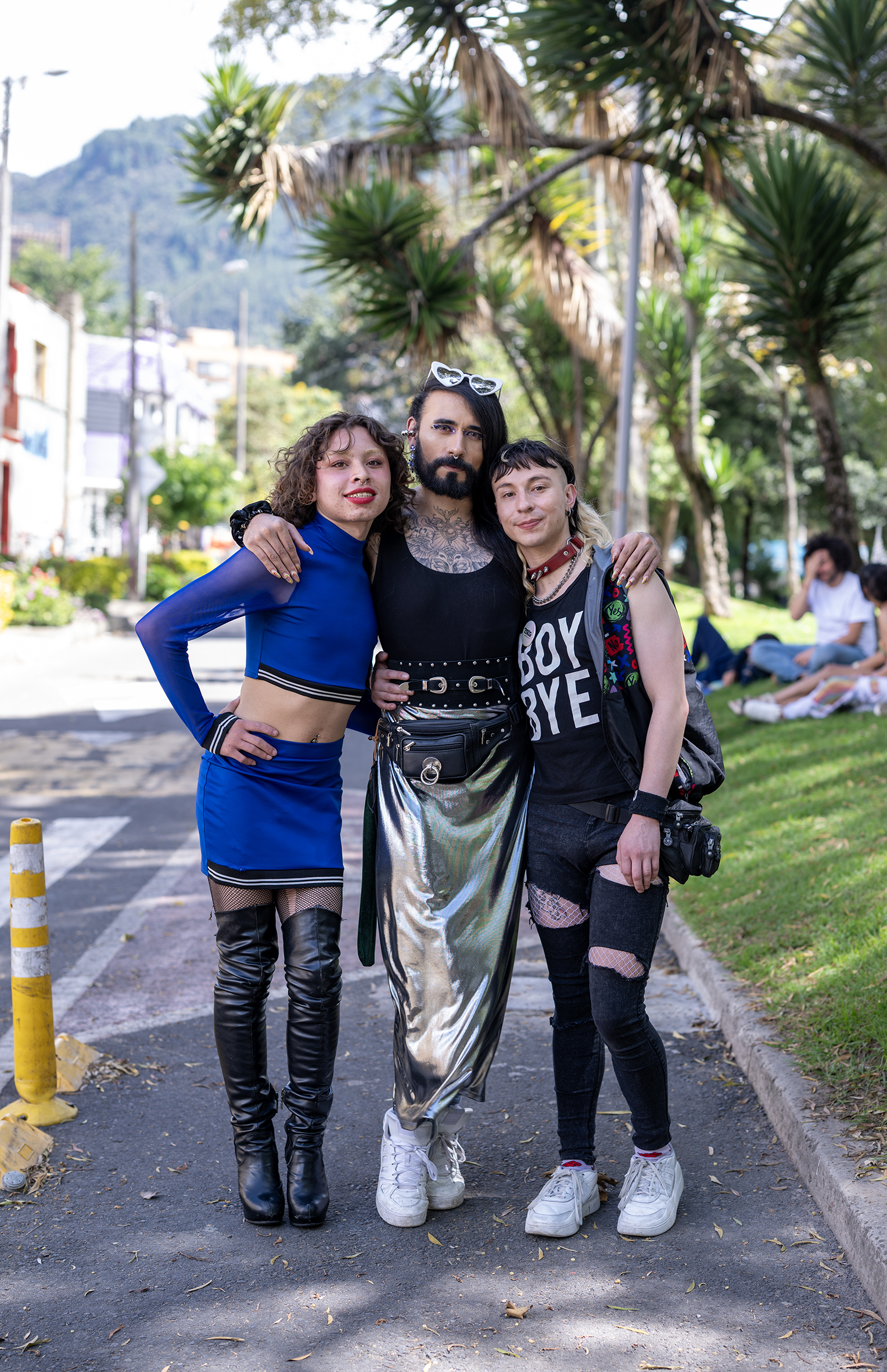 Dominica stands with Danne and another friend looking straight at the camera and smiling with their arms around each other