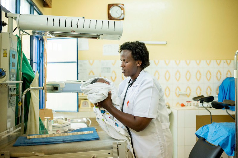 Midwife, Regine, does a post-natal check on Piece's newborn baby. 