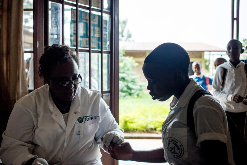 A young girl has the finger prick test by staff from the ABUBEF mobile clinic at Municipal Lycee of Nyakabiga school in Bujumbura. 