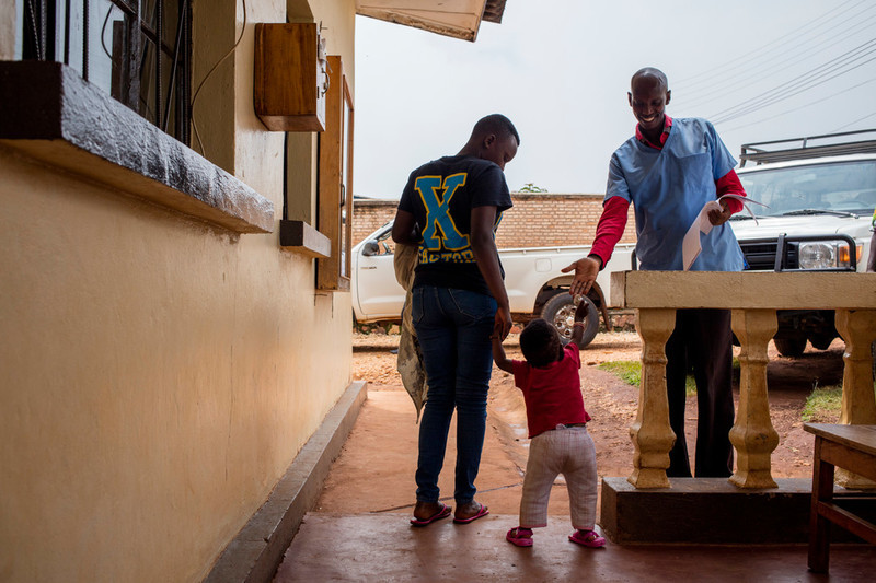 A mother and her baby greet a nurse as they leave at ABUBEF clinic in Ngozi. 