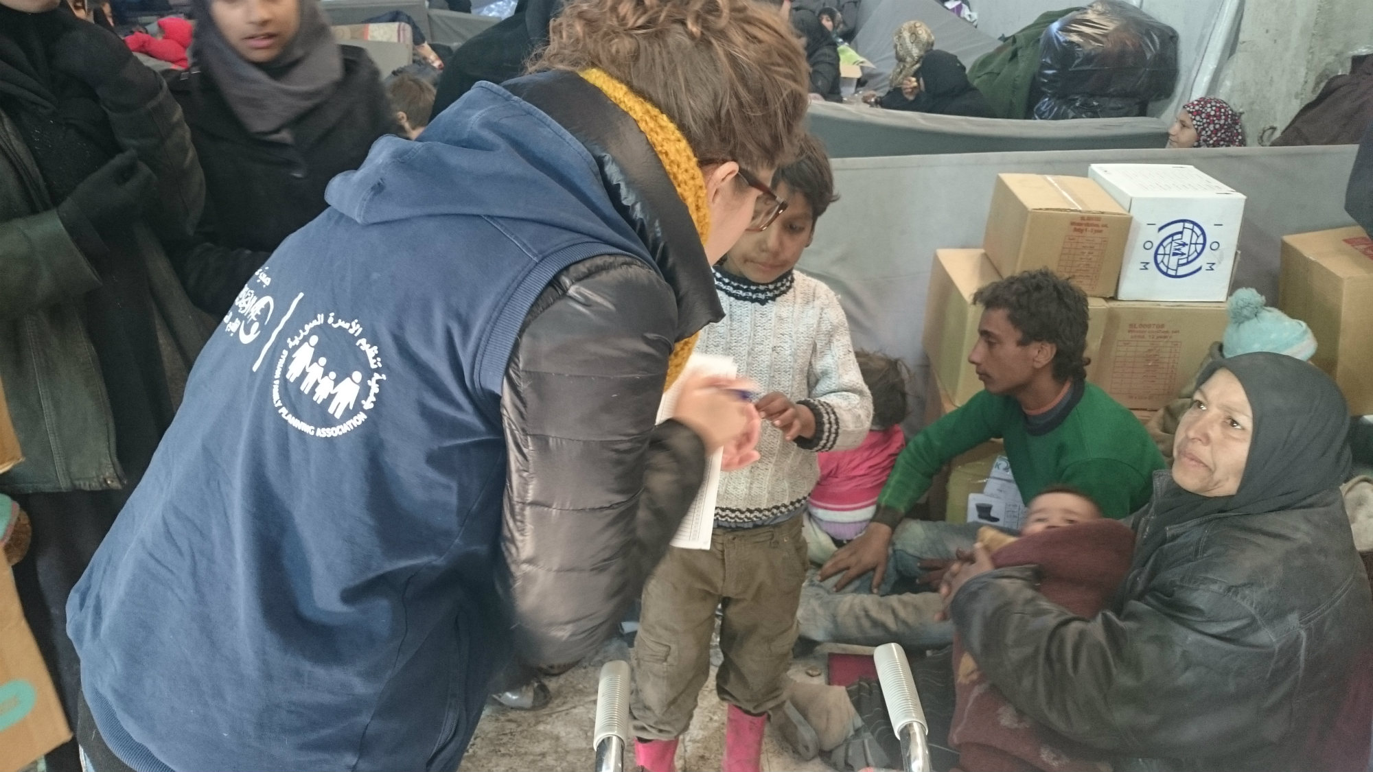 SFPA's staff talking to a woman in the camp