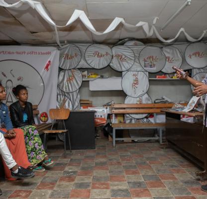 young people sit and listen to a sexual health peer educator 