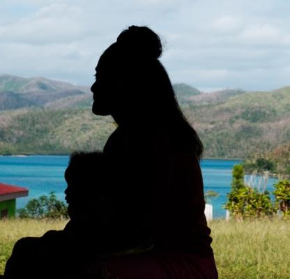 A silhouette of a woman and young child in Fiji