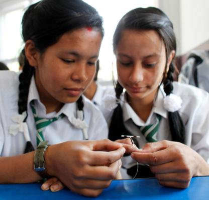 Two young people holding an IUD