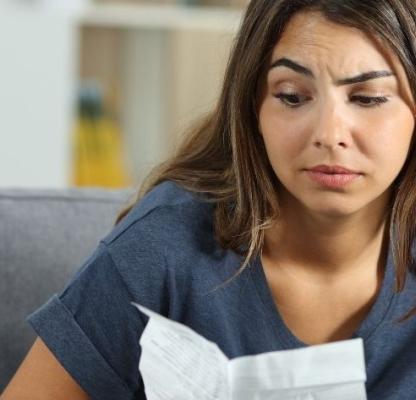 A confused-looking woman reads a leaflet