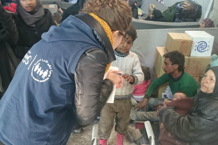 SFPA's staff talking to a woman in the camp