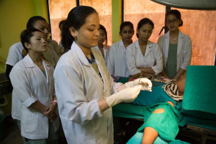 33 year old Ulmila Tamang having contraceptive implant inserted at the FPAN Kathmandu clinic. First year student nurses observe the procedure. 