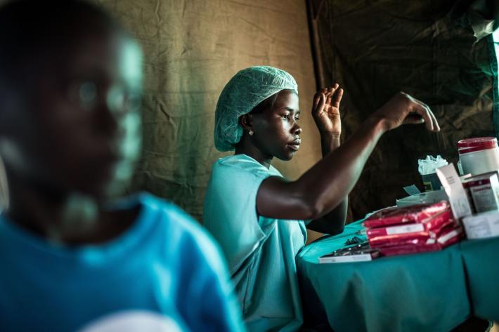Gertrude Atikuru, a nurse, dispenses medical equipment. 
