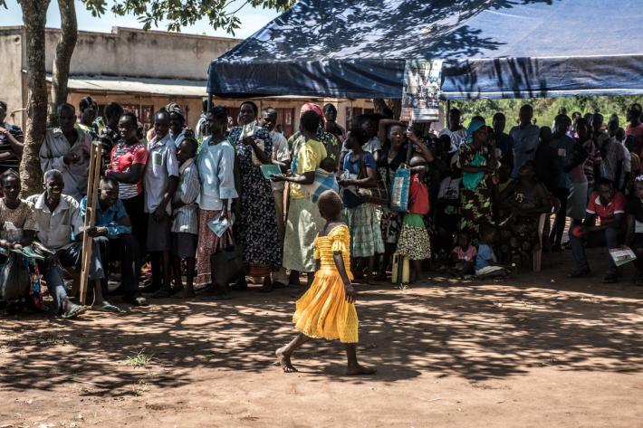 More than 200 men, women and children from the local community queue for services. 