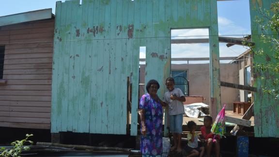 Jokaveti in front of her destroyed house