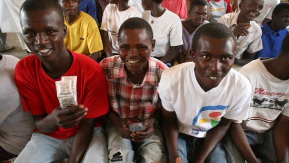 Group of young men. One holds condoms. 