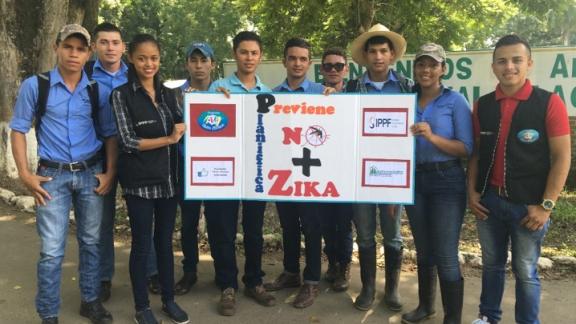 Youth volunteers from IPPF clinic in Honduras hold a banner about Zika