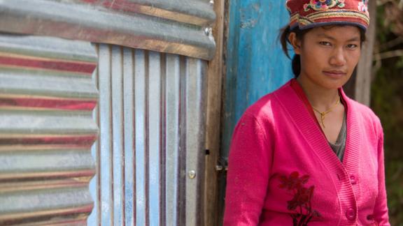 Young woman outside her home in Nepal. 