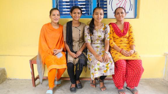 women sit outside a clinic in Nepal