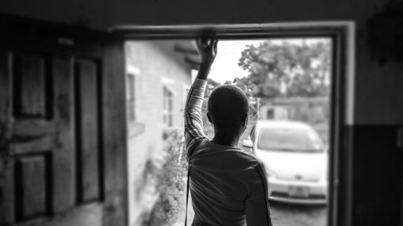 woman stand in door way - black and white