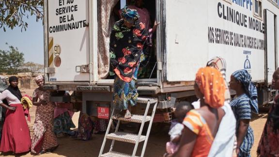 A woman exits the AMPPF mobile clinic