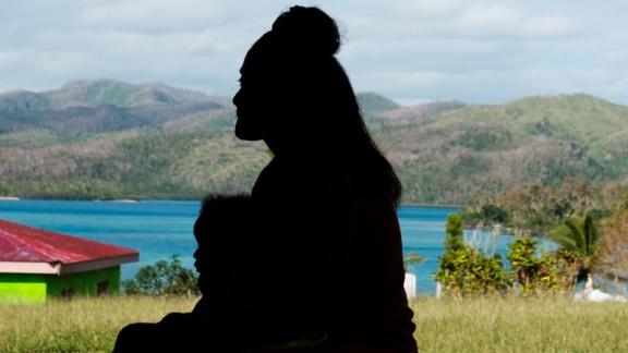A silhouette of a woman and young child in Fiji