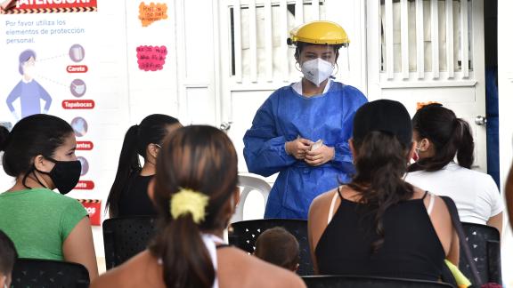A healthcare worker addresses a crowd of people
