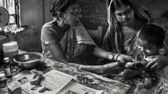A healthcare worker in India tends to a child - Amitava Chandra