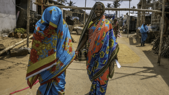 Two women walking on a road