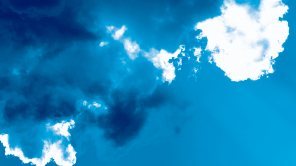 A blue sky with dark blue and white clouds