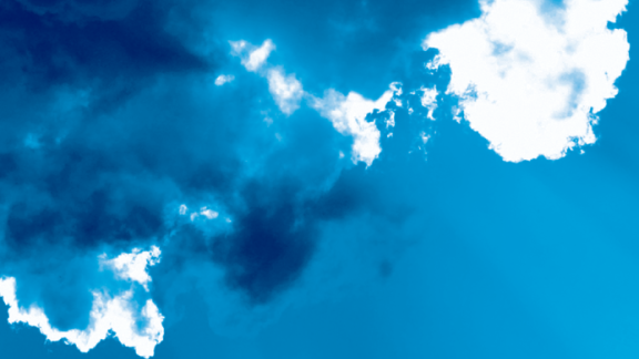 A blue sky with dark blue and white clouds